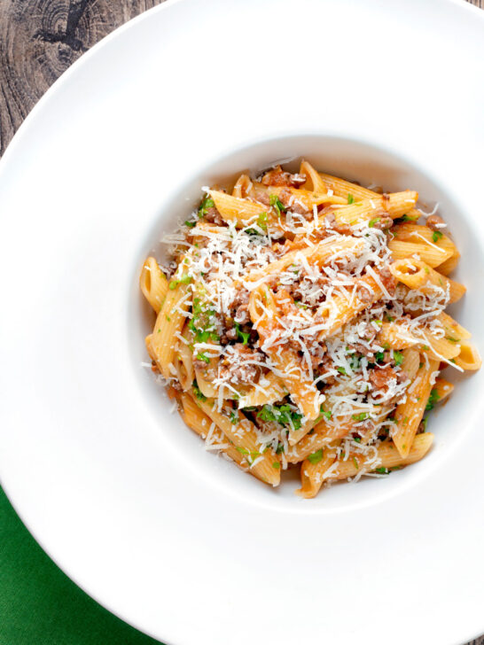 Overhead wild boar ragu or cinghiale al ragu with grated parmesan cheese.