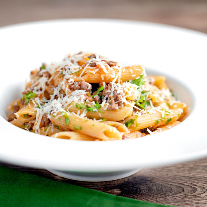 Wild boar ragu or cinghiale al ragu with penne pasta & grated parmesan cheese.