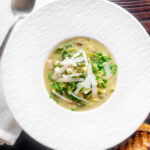 Overhead quick cabbage and cannellini bean soup with potatoes and capers.