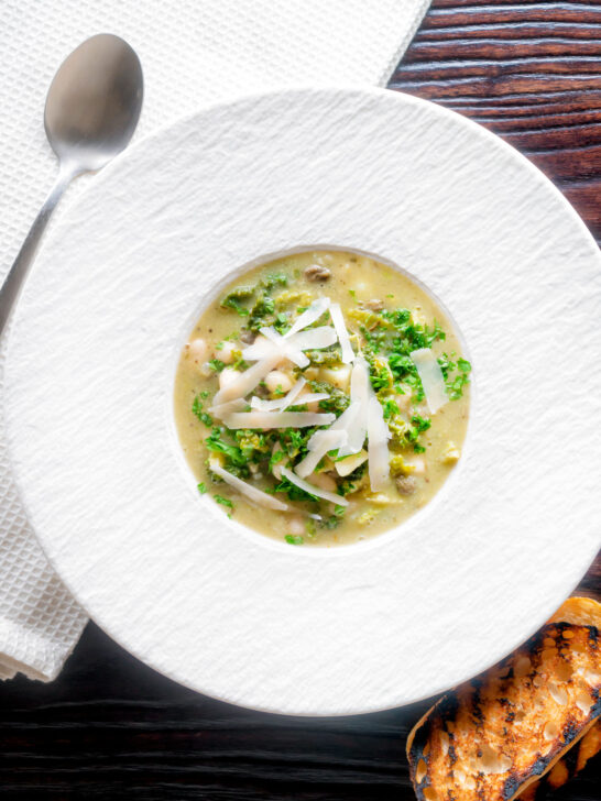 Overhead quick cabbage and cannellini bean soup with potatoes and capers.