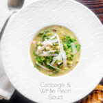 Overhead quick cabbage and cannellini bean soup with potatoes and capers featuring a title overlay.