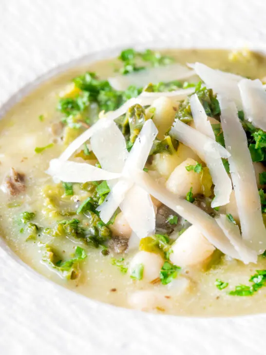 Close-up quick cabbage and cannellini bean soup with potatoes and capers.