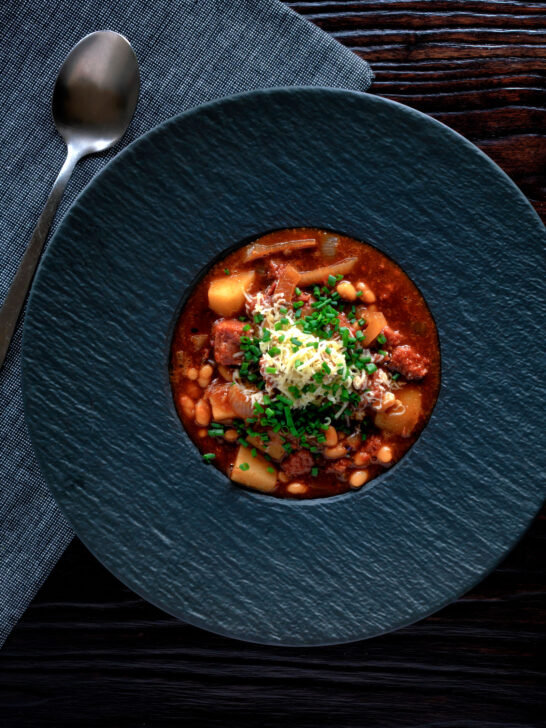 Overhead corned beef stew with baked beans and potatoes.