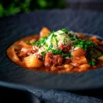 Corned beef stew with baked beans and potatoes.