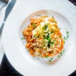 Overhead cheesy mashed potato topped fish finger and baked bean pie.
