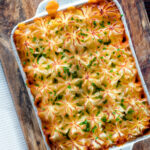 Overhead fish finger and baked bean pie topped with cheesy mash featuring a title overlay.