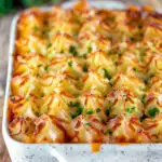 Fish finger and baked bean pie topped with cheesy mash featuring a title overlay.