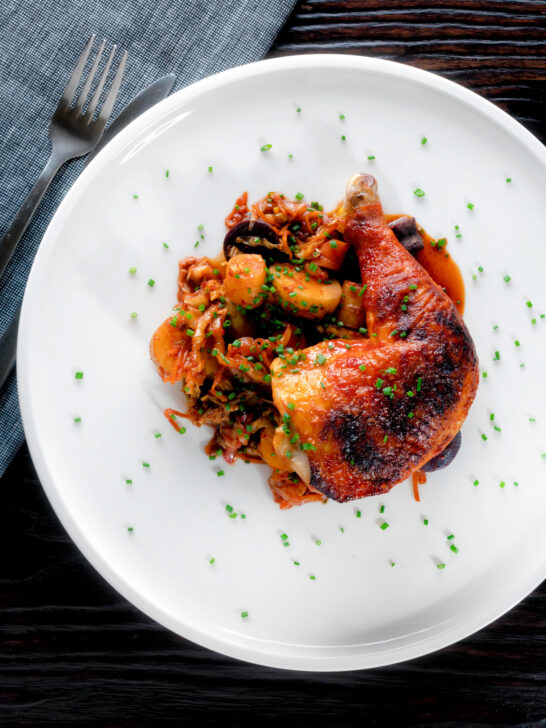 Overhead kimchi chicken leg stew with potatoes and carrots.