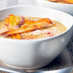 Roasted curried parsnip soup with paprika and crispy fried carrot strips.