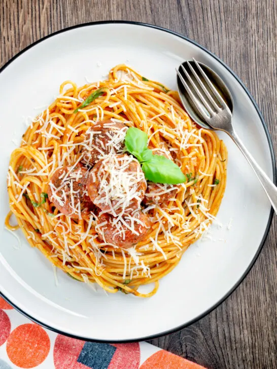 Overhead homemade spaghetti and meatballs with grated parmesan cheese.