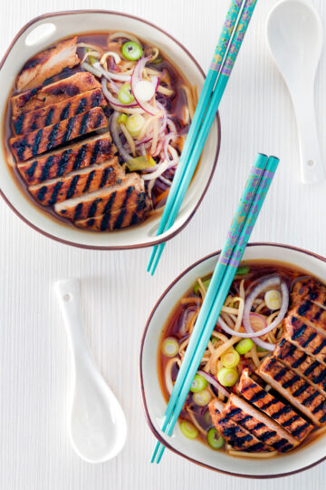 Overhead spicy pork ramen soup with spring onions.