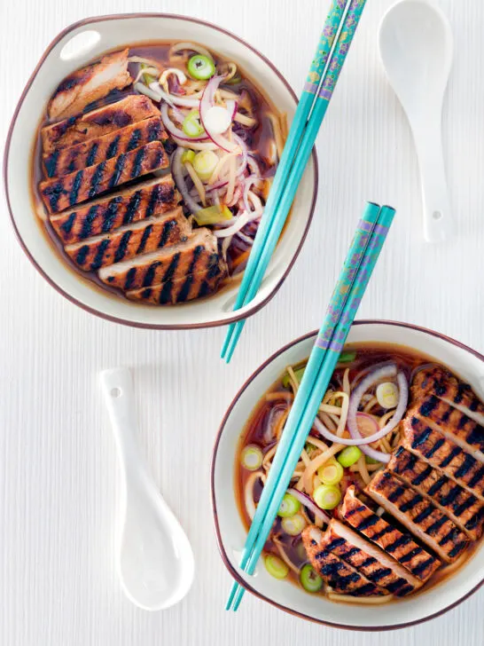 Overhead spicy pork ramen soup with spring onions.