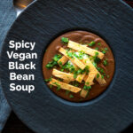 Overhead spicy vegan black bean soup with Mexican influences featuring a title overlay.