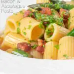 Close-up bacon and asparagus pasta with mezzi rigatoni and fresh parsley featuring a title overlay.