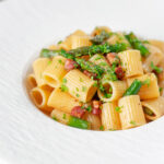 Bacon and asparagus pasta with mezzi rigatoni and fresh parsley.