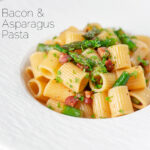 Bacon and asparagus pasta with mezzi rigatoni and fresh parsley featuring a title overlay.