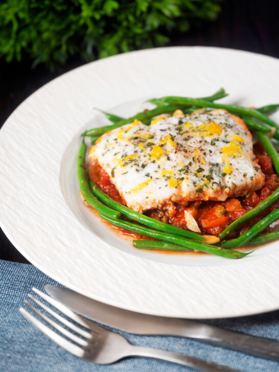 White fish baked in tomato sauce with green beans amandine.