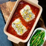 Overhead baked cod with tomato sauce served with green bean amandine featuring a title overlay.