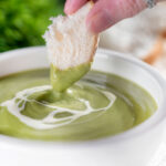 Crusty bread dipped into creamy broccoli and stilton soup.