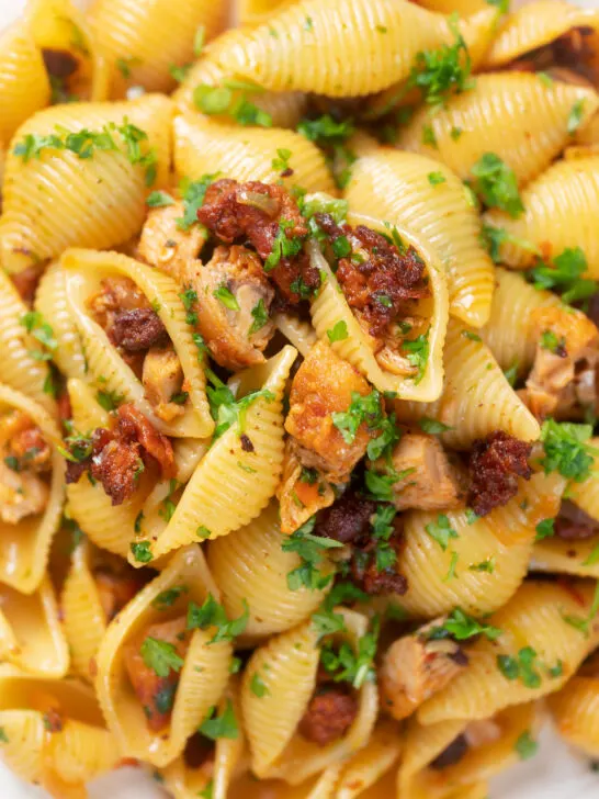 Close-up overhead chicken thigh and chorizo sausage pasta.