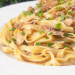 Close-up chicken and mushroom pasta with fresh chives.
