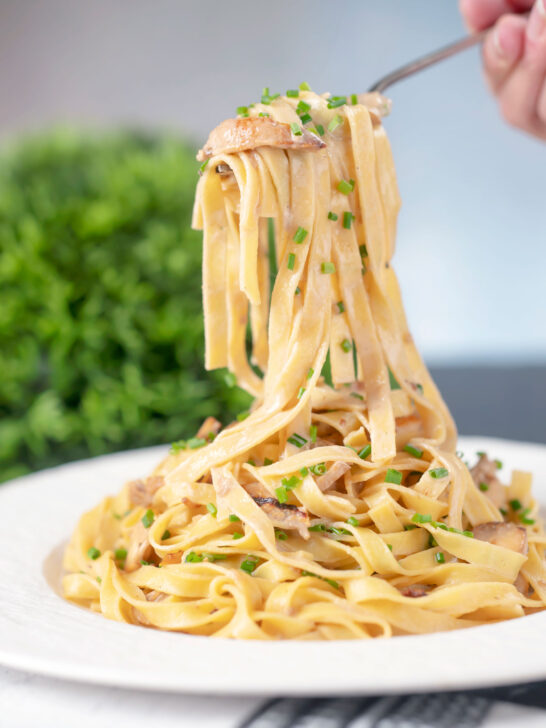 Easy chicken and mushrooom tagliatelle pasta being eaten by a fork.