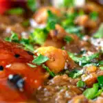 Close-up Indian-inspired chickpea and lentil curry with kachumber salad and mango chutney featuring a title overlay.