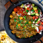 Overhead Indian-inspired chickpea and lentil curry with kachumber salad and mango chutney.