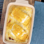 Overhead cod mornay with a breadcrumb topping in a baking dish featuring a title overlay.