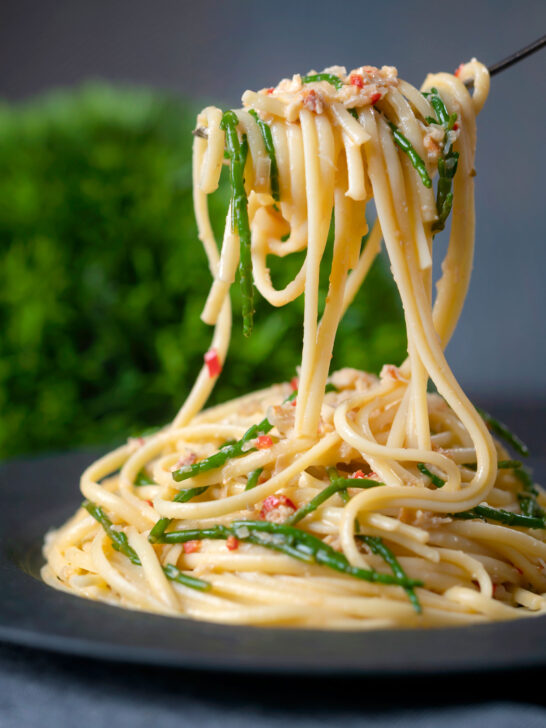 Crab linguine with chilli and samphire being picked up with a fork.