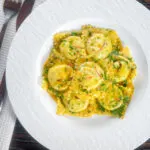 Overhead crab and ricotta ravioli with a saffron and dill butter sauce.