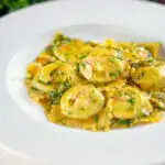 Cab and ricotta ravioli with a saffron and dill butter sauce featuring a title overlay.