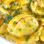 Close-up crab and ricotta ravioli with a saffron and dill butter sauce.