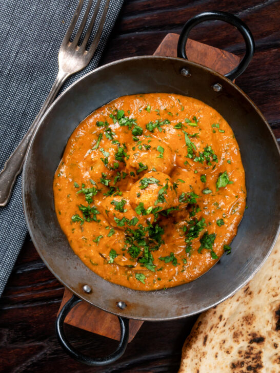 Overhead dum aloo baby potato curry with a tomato gravy.