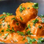 Close-up dum aloo tinned potato curry with a tomato gravy.