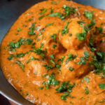 Close-up dum aloo baby potato curry with a tomato gravy.