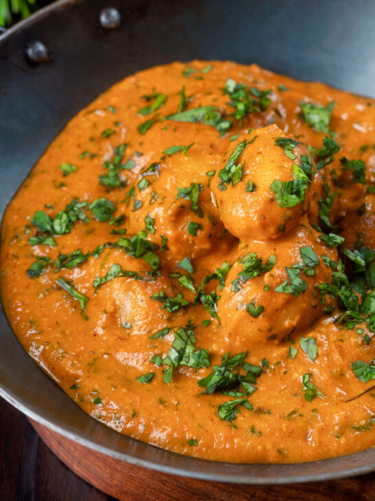 Close-up dum aloo baby potato curry with a tomato gravy.