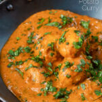 Close-up dum aloo baby potato curry with a tomato gravy featuring a title overlay.