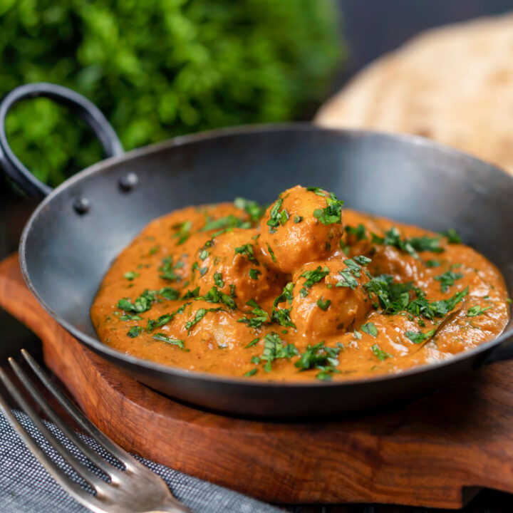 Indian dum aloo baby potato curry with fresh coriander and naan bread.
