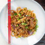 Overhead Chinese salt and pepper chicken served with noodles.
