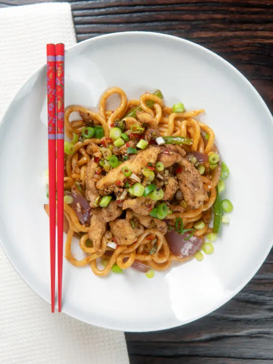 Overhead Chinese salt and pepper chicken served with noodles.