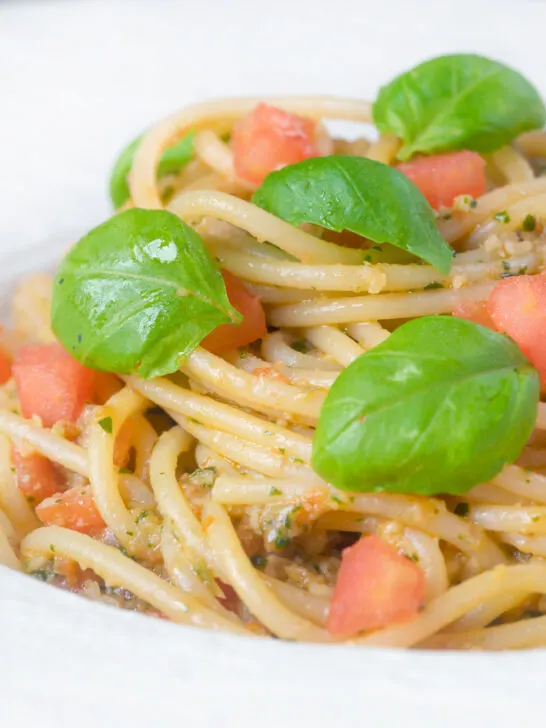 Close-up pasta pesto alla trapanese fresh tomato and basil.