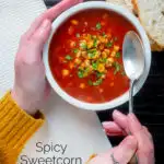 Overhead spicy vegan sweetcorn soup with tomato and chipotle being eaten featuring a title overlay.