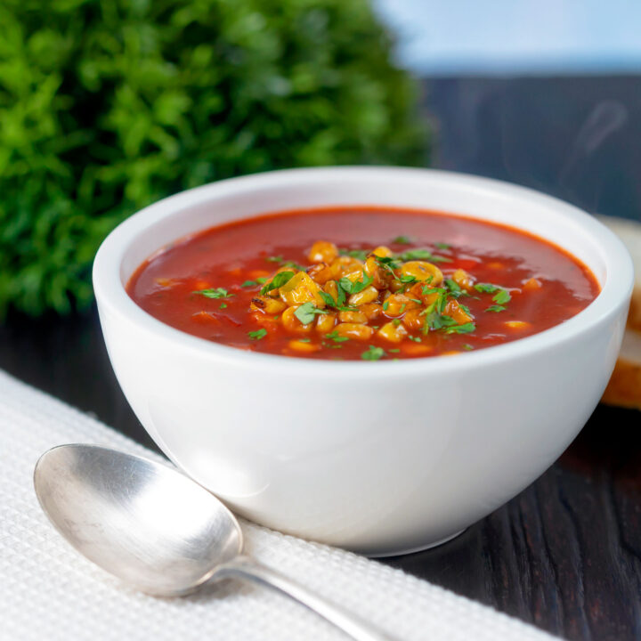 Spicy sweetcorn and tomato soup with chipotle in a white bowl.