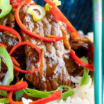 Close-up stir-fried beef steak in oyster sauce with fresh chilli and rice.