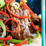Close-up stir-fried beef steak in oyster sauce with fresh chilli and rice.