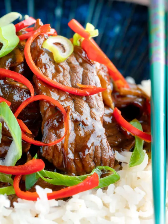 Close-up stir-fried beef steak in oyster sauce with fresh chilli and rice.