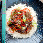 Overhead Chinese stir-fried beef in oyster sauce with fresh chilli and rice.