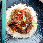 Overhead Chinese stir-fried beef in oyster sauce with fresh chilli and rice.