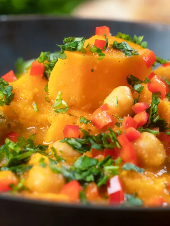 Close-up sweet potato and chickpea curry with coconut milk and fresh coriander.